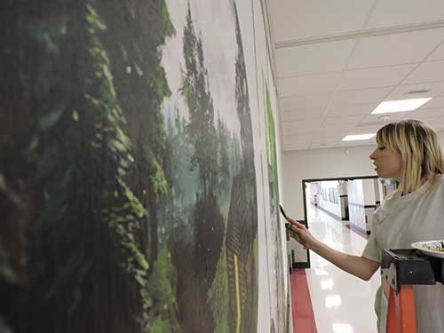 photo of Justine Musick working on Hallowell Elementary Historical Mural